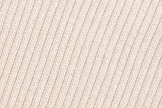 Soft beige ribbed knit fabric pattern close up as background
