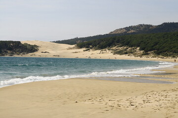 La plage naturelle et sauvage de Bolonia, située à une vingtaine de kilomètres au nord de Tarifa en Andalousie en Espagne, a une grande dune de sable blanc de 30 mètres de haut et 200 mètres de large