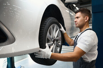 Worker changing car wheel in tire fitting