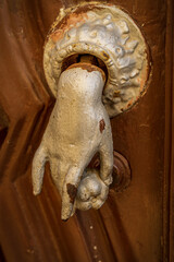 Rustykalny element ozdobny, kołatka do drzwi w kształcie dłoni.  - obrazy, fototapety, plakaty