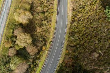 aerial view of a lone bicyclist cycling on a mountain road