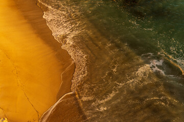 Piękna piaszczysta plaża w promieniach zachodzącego słońca z lotu ptaka, Algarve, Portugalia.  - obrazy, fototapety, plakaty
