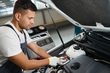 Male checking technical condition of auto parts