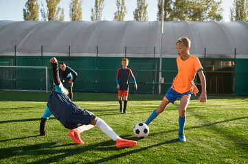 Young boys playing soccer game during junior competition at sport school
