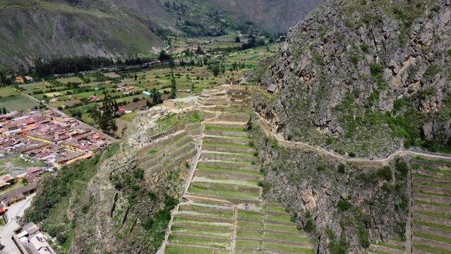 Birdseye view flying away from ancient ruins and village in Peru.