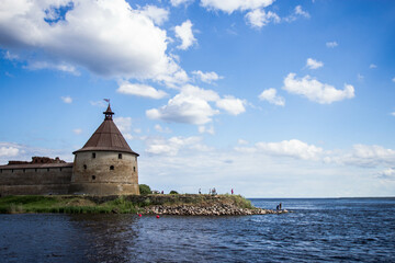 Fototapeta na wymiar The tower of the Oreshek fortress on the background of Ladoga