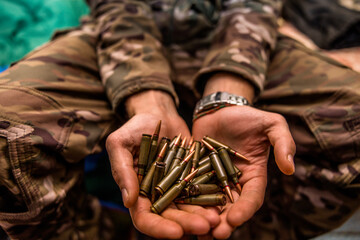 a handful of bullets in the hands of a soldier. bullet shop