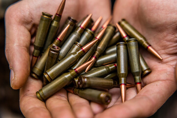 a handful of bullets in the hands of a soldier. bullet shop