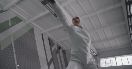 Muslim fencer hitting air with foil - Powered by Adobe
