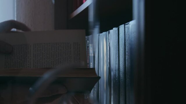 A man choosing a book from a bookshelf