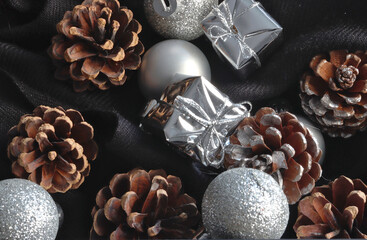 close-up view of christmas silver ornaments in the shape of balls and wrapped gifts and pine cones...