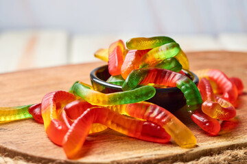 Colored gummy worms in a bowl.