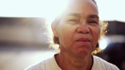 South American senior woman portrait face closeup standing outside with serious expression. Older...