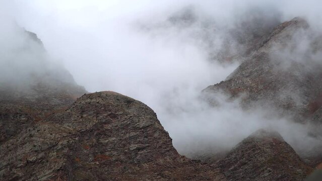 4K shot of clouds above the mountain peaks during the storm at Jispa in Lahaul Spiti district at Himachal Pradesh in India. Clouds covers the peaks of the mountains. Natural background.	