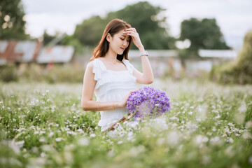 Obraz premium Beautiful young woman in white dress in flower garden at Chiang Mai, Thailand
