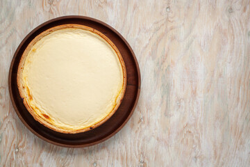 Cheesecake New York  on a plate on a wooden background. Top view. Copy space