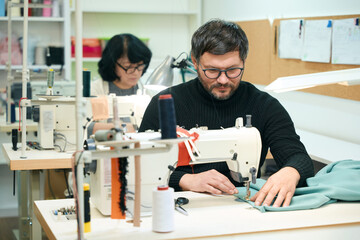 Bearded man is scribbling on a sewing machine