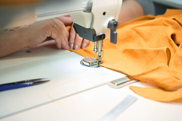 Female seamstress at her workplace scribbles on a sewing machine