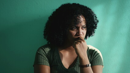 Fototapeta na wymiar A concerned African American young woman. A pensive hispanic latin girl thinking in doubt