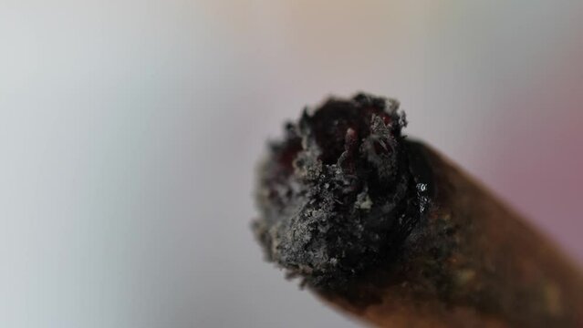 Close up of woman lighting marijuana joint at home, macro shot of CBD medical marijuana weed with fire. 