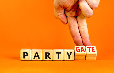 Party and partygate symbol. Concept words Party and Partygate on wooden cubes. Businessman hand. Beautiful orange table orange background. Business party and partygate concept. Copy space.