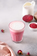 Beetroot latte of beet powder on gray background. Trendy healthy vegan drink. Vertical format.