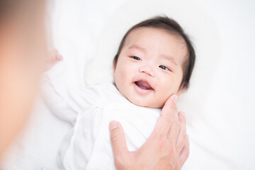 パパと遊んで楽しそうに笑顔になる生後2か月の赤ちゃん