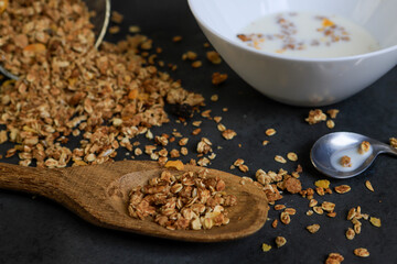 Granola grains and plate of milk on black background. Healthy food