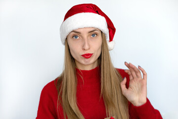 Beautiful blonde girl in a Santa hat and a red sweater.