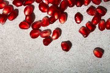 Pomegranate seeds, grains of pomegranate on a light background. Source of iron. Seasonal winter fruits