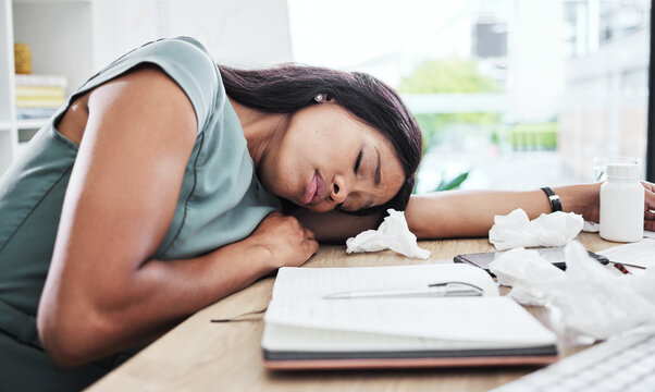 Woman, sick and sleeping on office desk in burnout suffering from stress, depression or mental health issues. Tired female employee with flu resting, dreaming or asleep on computer table at work