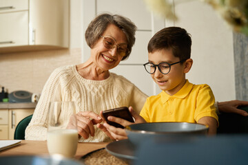 Boy helping to grandmother find information in smartphone
