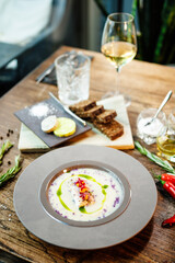 Jerusalem artichoke-almond cream soup with scallop roll. Leek, almond milk, garlic. Delicious healthy Jewish traditional food closeup served for lunch on a table in modern gourmet cuisine restaurant