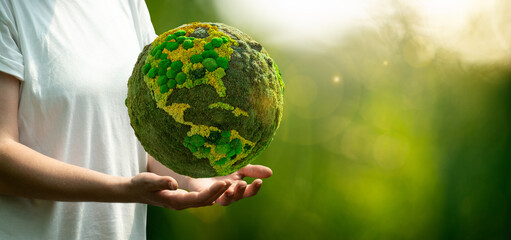 Woman holding a green planet Earth. Symbol of sustainable development and renewable energy - obrazy, fototapety, plakaty