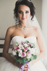 Naklejka premium Portrait of beautiful bride with fashion veil at wedding morning