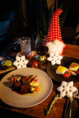 Deer tenderloin and dessert. Christmas table served for eve celebration event. Delicious healthy traditional food served for lunch in modern gourmet restaurant