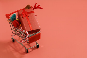 Christmas decorations in a cart, gifts, Christmas tree, red gold christmas ball and Santa's Cane isolated on red background with copy space. Christmas, winter, new year concept. close up, top view.