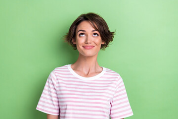 Photo of optimistic bob hairdo millennial lady look up wear white striped t-shirt isolated on green...