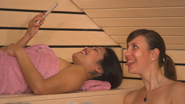 CLOSE UP: Smiling young women creating memories from relaxing at sauna and spa