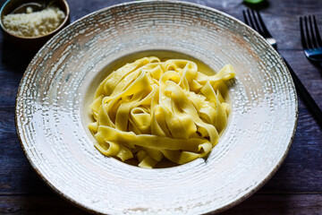 Italian food . Fresh home made  tagliatelle vegetarian  egg pasta  with ,parmesan cheese ,fresh parsley  and black pepper.Pasta cacio e pepe