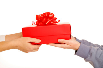 Female hands holding red gift box with red ribbon giving presetn to somebody on grey background. Present for birthday, valentine day, Christmas, New Year. Congratulations background copy space