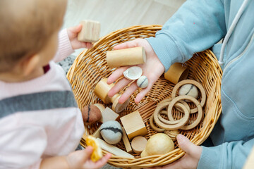 Close up of mother and toddler playing with montessori toys
