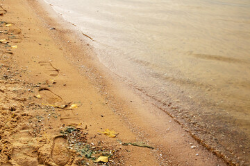 Human footprints on the sand near the water