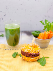 green delicious Burger with spinach smoothie on a concrete background