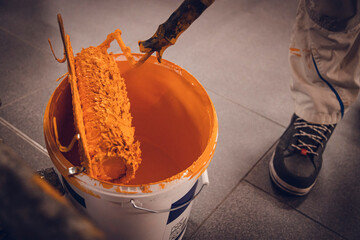 Maler mit orangener Farbrolle