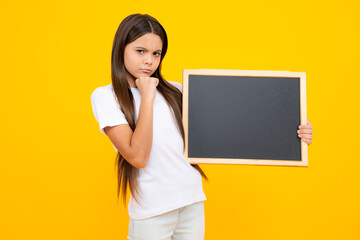 Fototapeta na wymiar Teen schoolgirl hold blackboard. Child advertising. Back to school. Thinking face, thoughtful emotions of teenager girl.