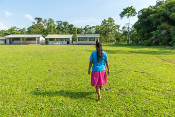 Indigenous Kichwa woman in traditional clothing walking in the Pilche community near Yasuni national park, Amazon rainforest, Ecuador.