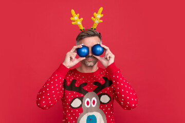 happy new year. merry christmas. man in winter sweater and party antlers.