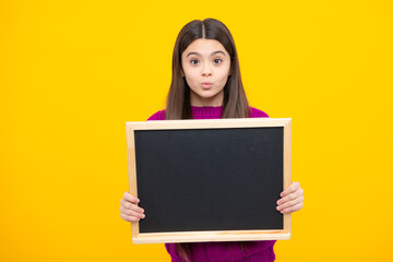 School sales board. Cheerful teenage girl kid hold blackboard chalkboard with copy space. Funny face.