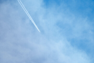 Fondo con detalle de cielo de tonos azules con avion en vuelo y estela